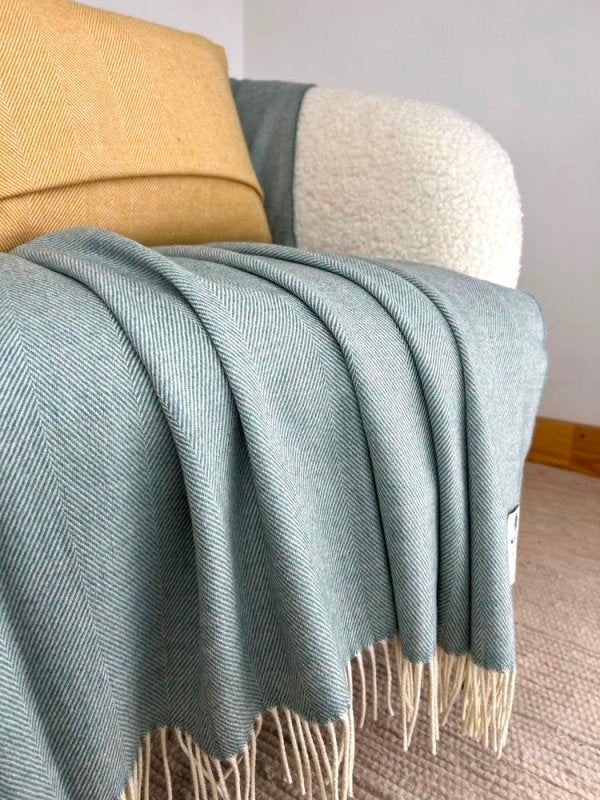 Couverture en laine d'agneau mérinos - Aigue-marine à Chevrons -  McNutt of Donegal - sur fauteuil